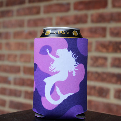 Purple can cooler with a Mama's white mermaid logo against a brick wall background