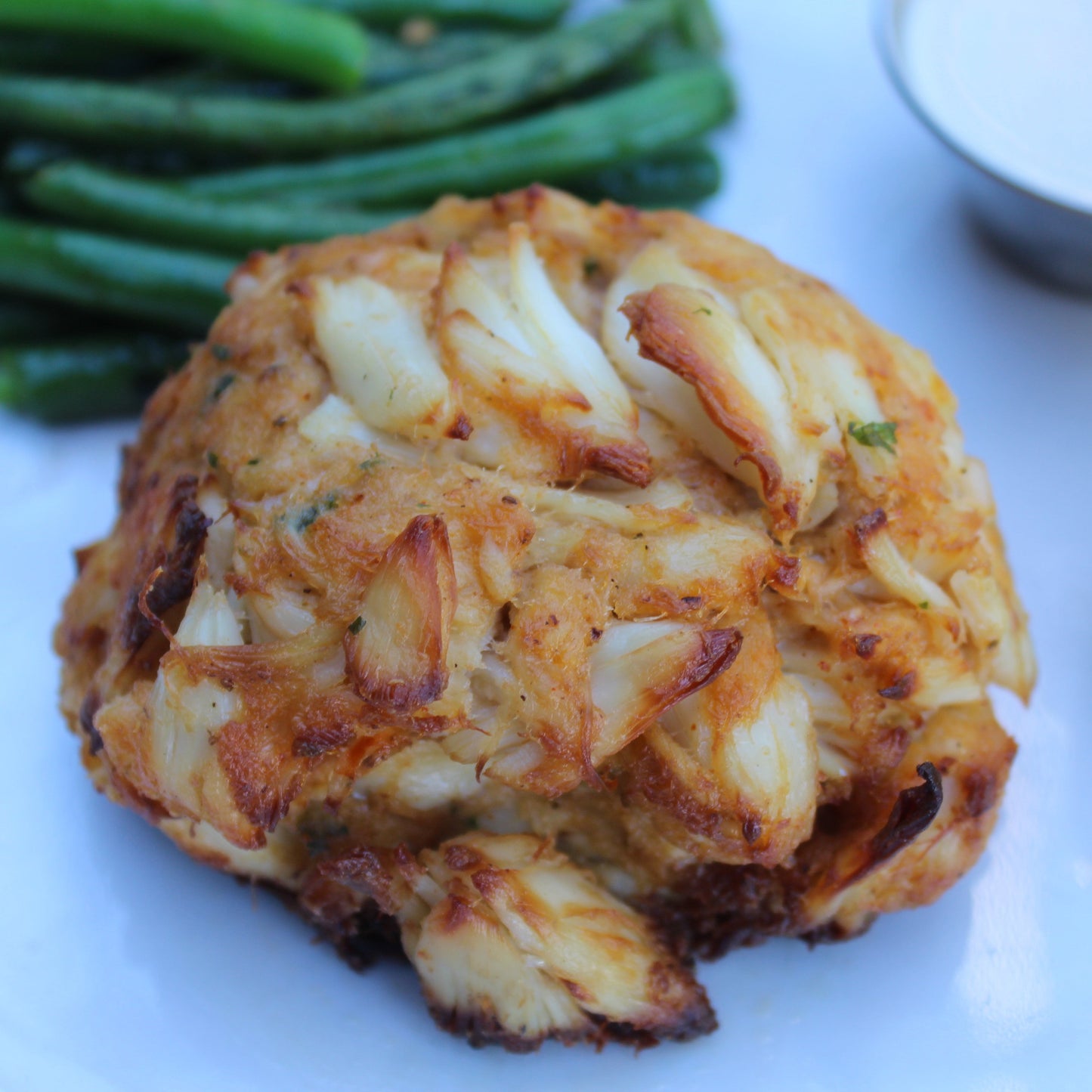 Jumbo Jump Crab Cake on a plate with a lemon and tartare sauce